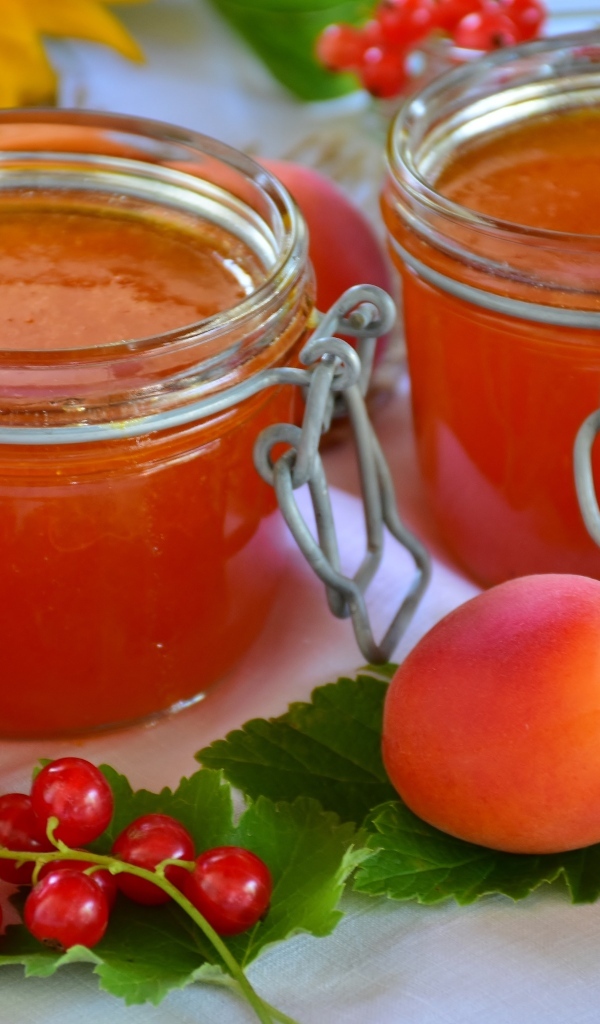 Джем на столе с абрикосами и красной смородиной