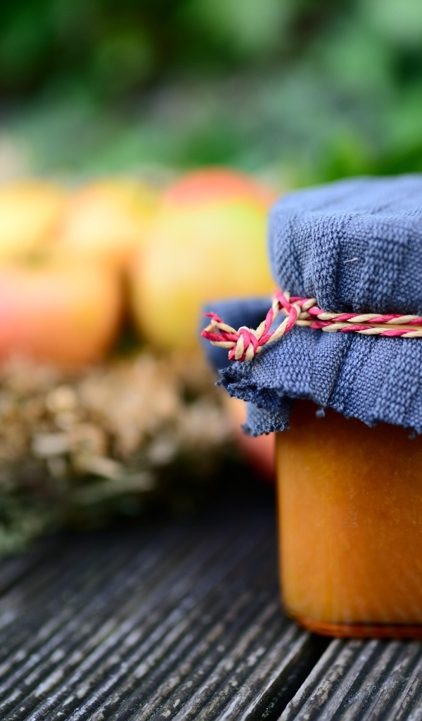 Банка яблочного джема на столе крупным планом