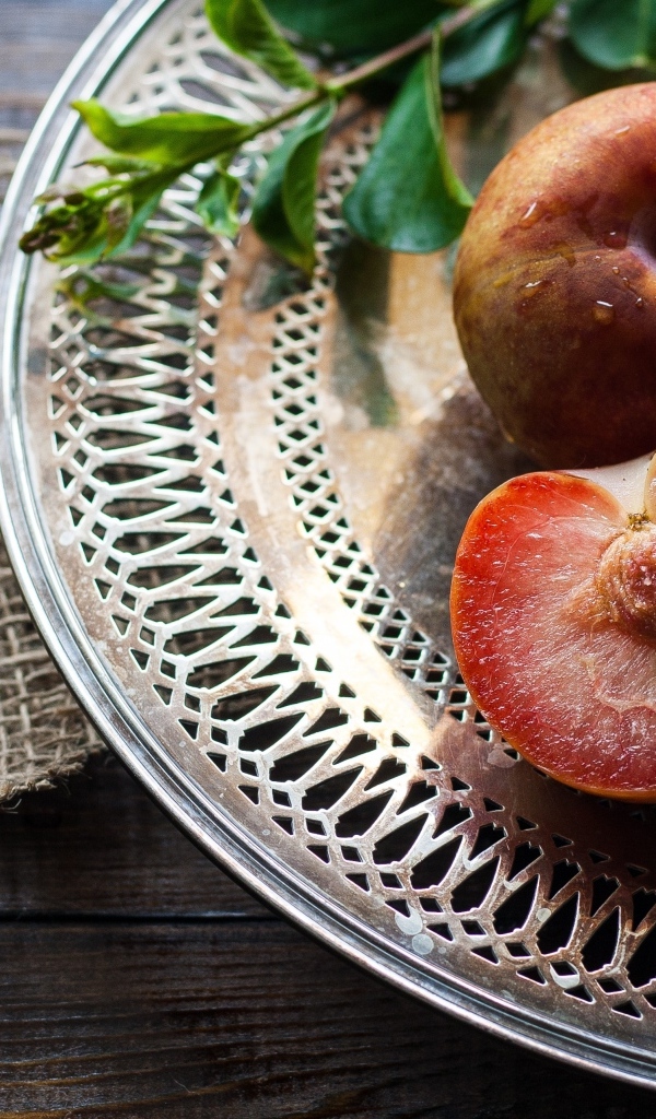 Сочные сливы на тарелке на столе