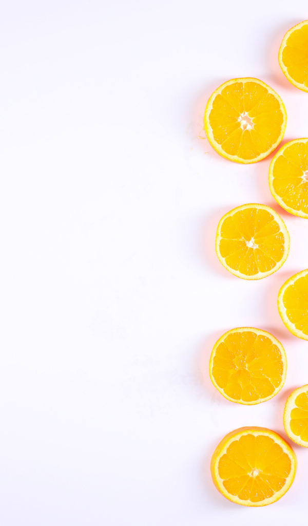 Много половинок лимона и апельсина на белом фоне