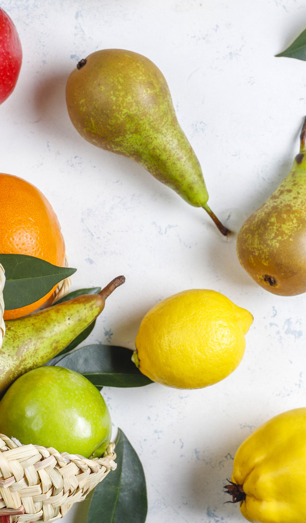 Груши, яблоки и апельсины с сумкой на столе