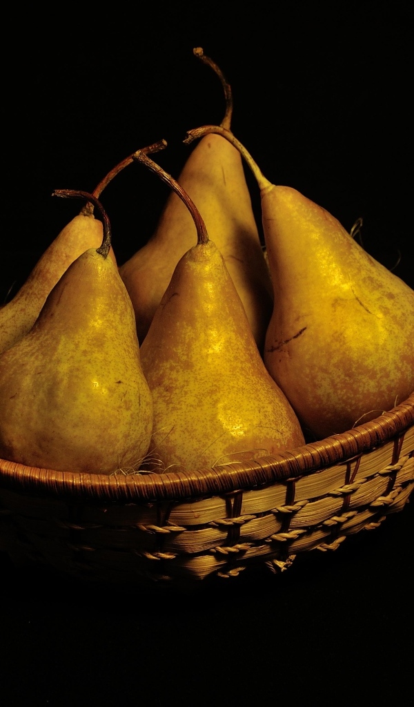 Груши в корзине на черном фоне