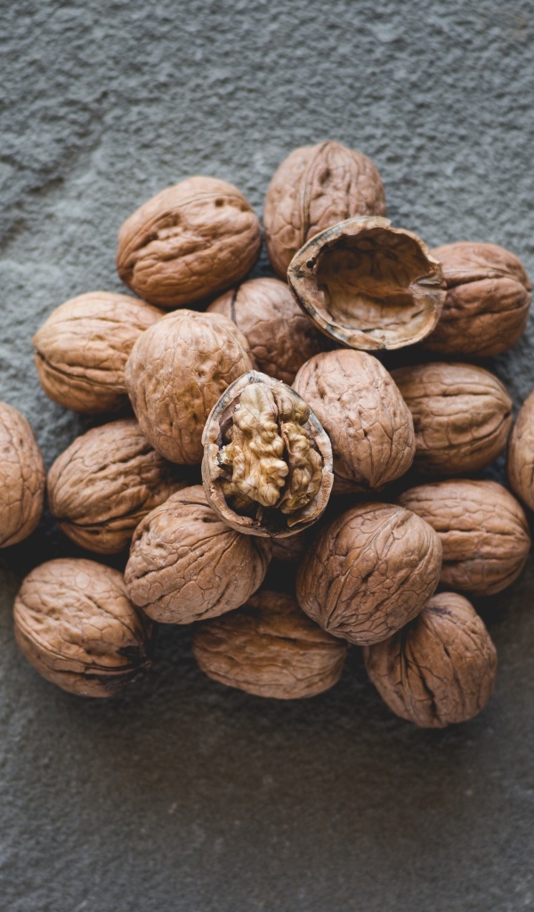 Куча грецких орехов на сером столе