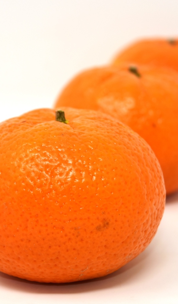 Три больших спелых мандарина на столе