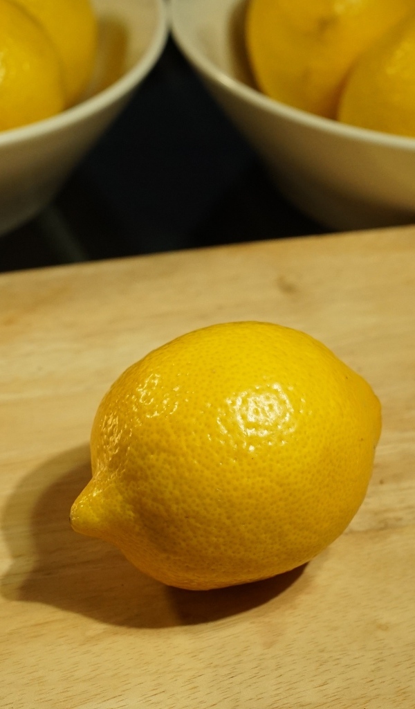 Желтый лимон на деревянной доске на столе