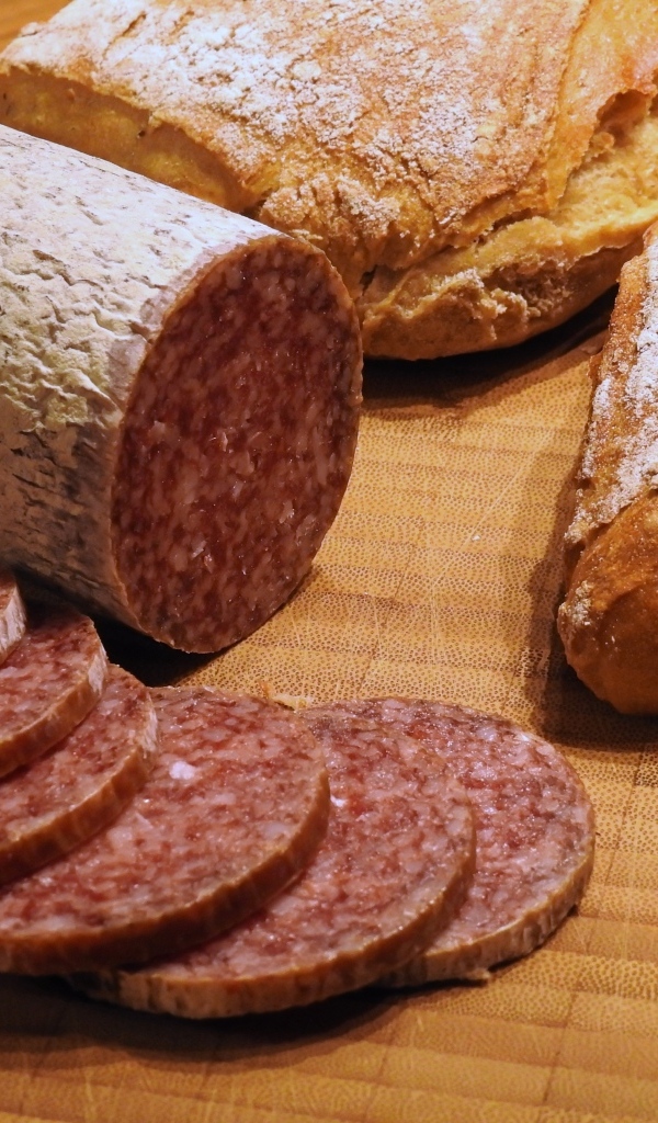 Хлеб с нарезанной колбасой на столе