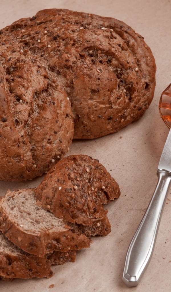 Ржаной хлеб со сливочным маслом и ножом на столе