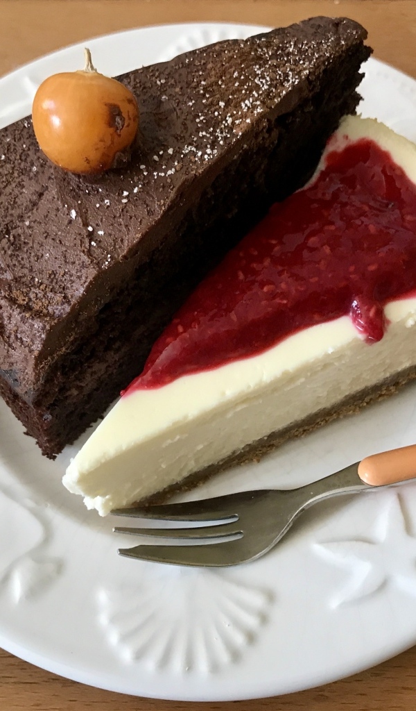 Кусок шоколадного торта и чизкейка на тарелке