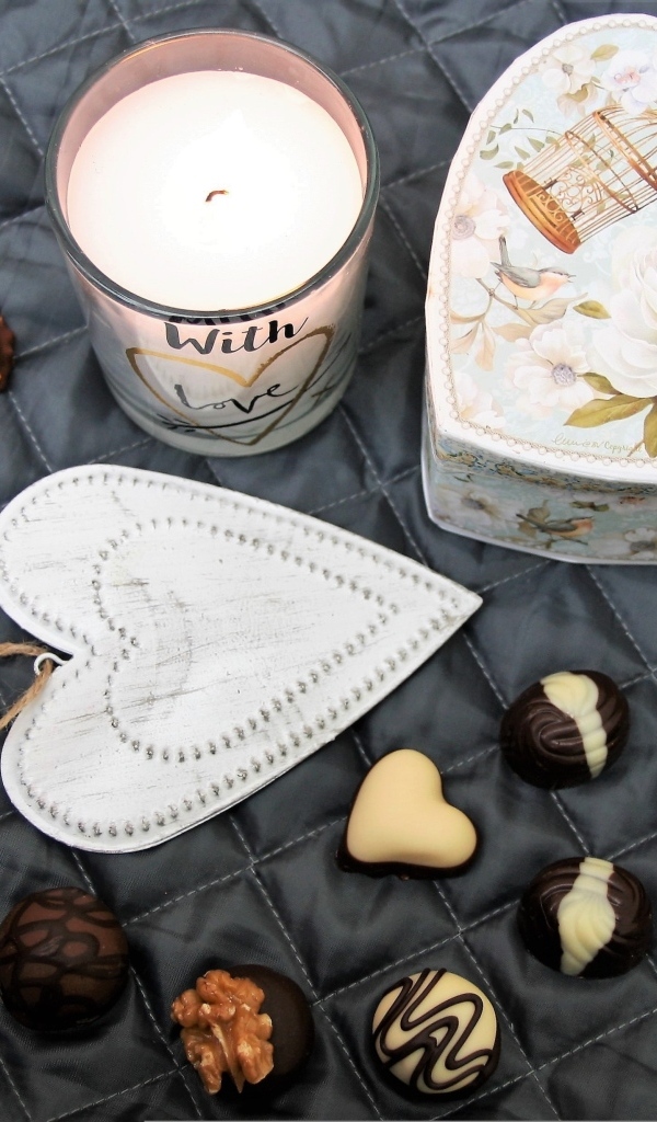 Коробка на кровати с конфетами и свечой