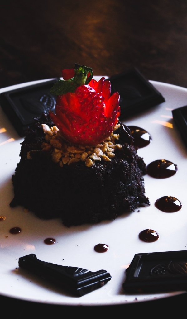 Десерт брауни на большой белой тарелке с шоколадом