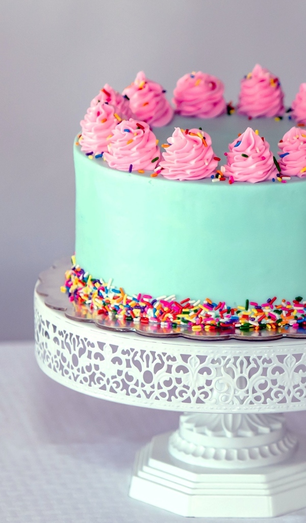 Торт с голубой глазури с розовым кремом на столе