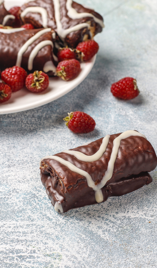 Шоколадные рулетики с ягодами малины на столе