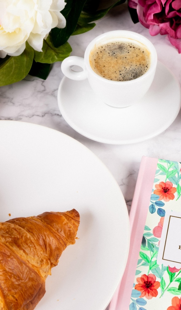 Круассаны на столе с кофе и цветами