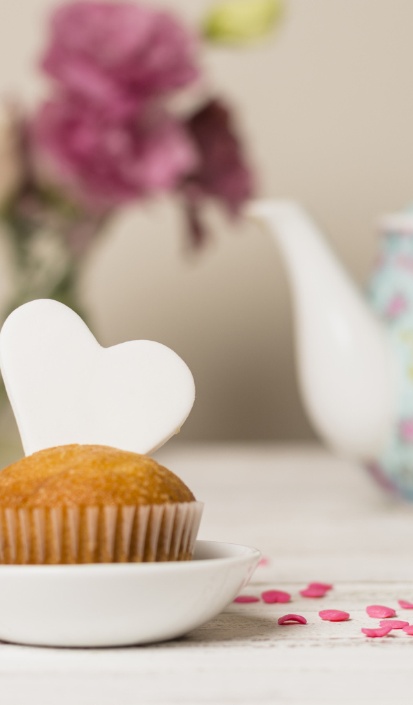 Кекс с сердечком на столе с посудой