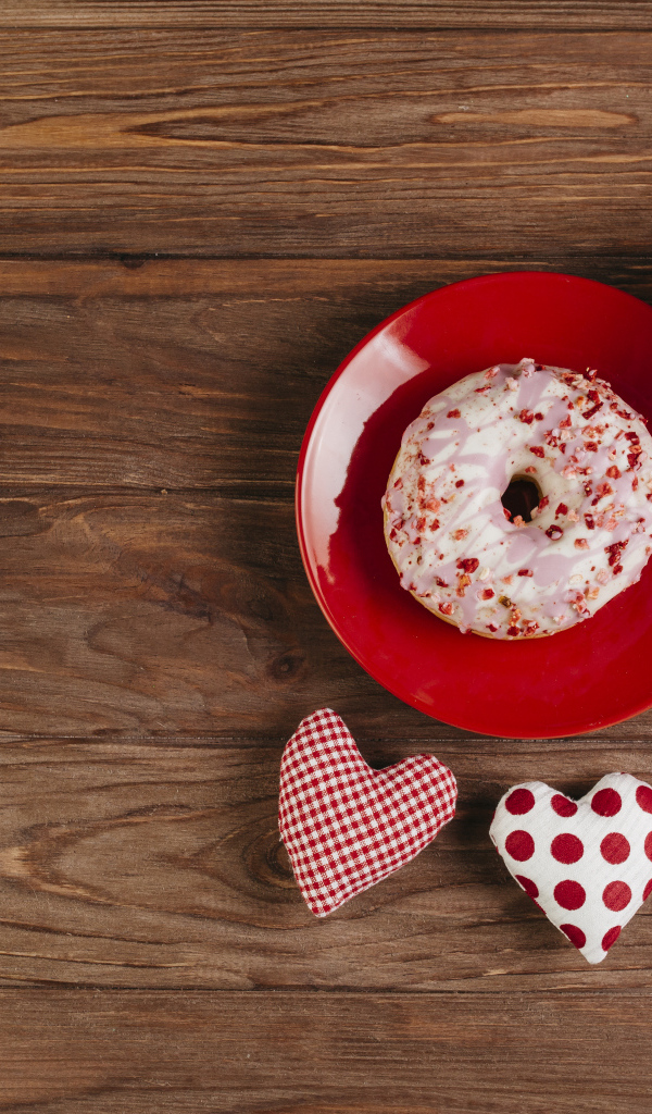 Пончик на столе с будильником, чашкой кофе и сердечками