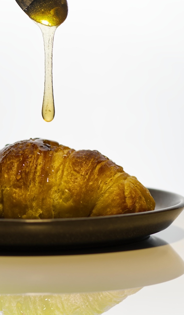 Свежий круассан с медом на завтрак