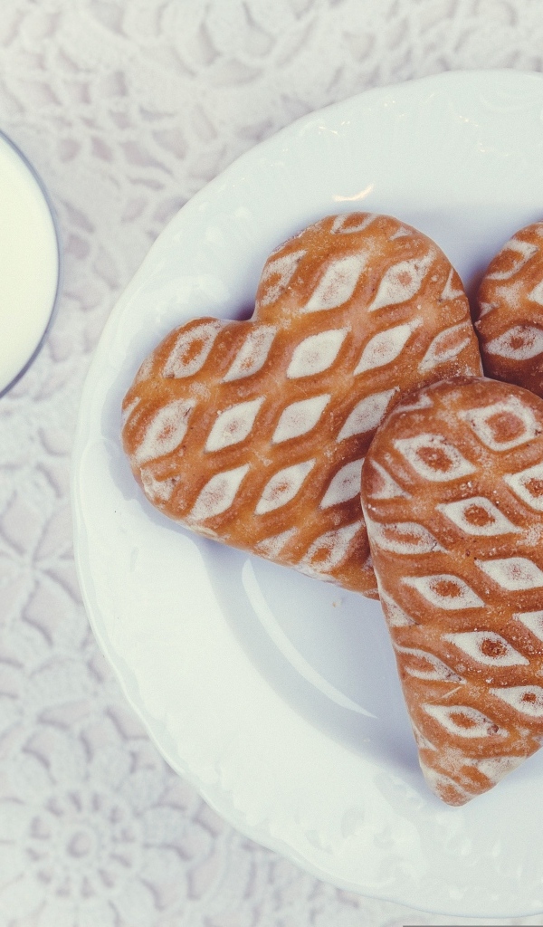 Печенье в форме сердца на столе с молоком