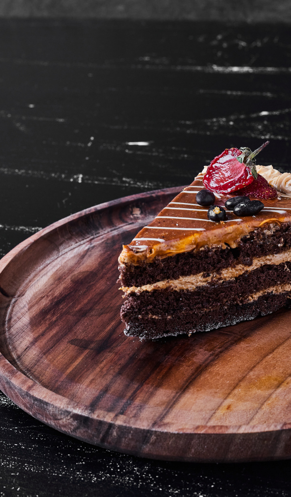 Большой кусок торта на деревянной доске