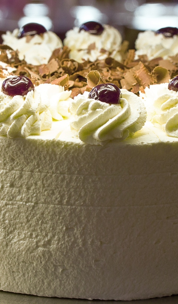 Большой белый торт с ягодами вишни