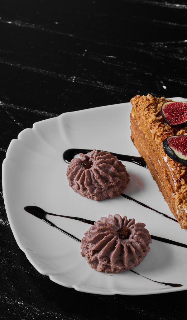 Кусок торта с печеньем на белой тарелке