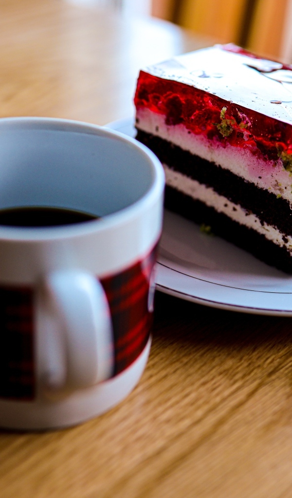 Кусок торта с чашкой кофе на деревянном столе