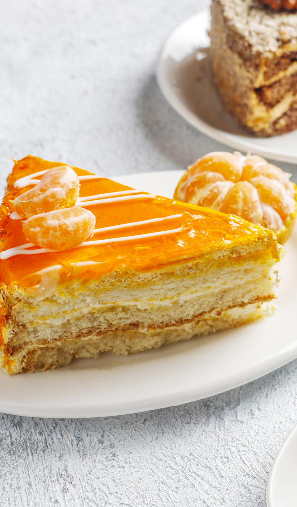 Кусок торта с мандарином на белой тарелке