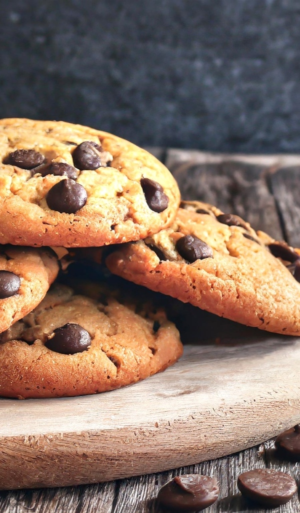 Круглое печенье с шоколадом на столе со стаканом молока