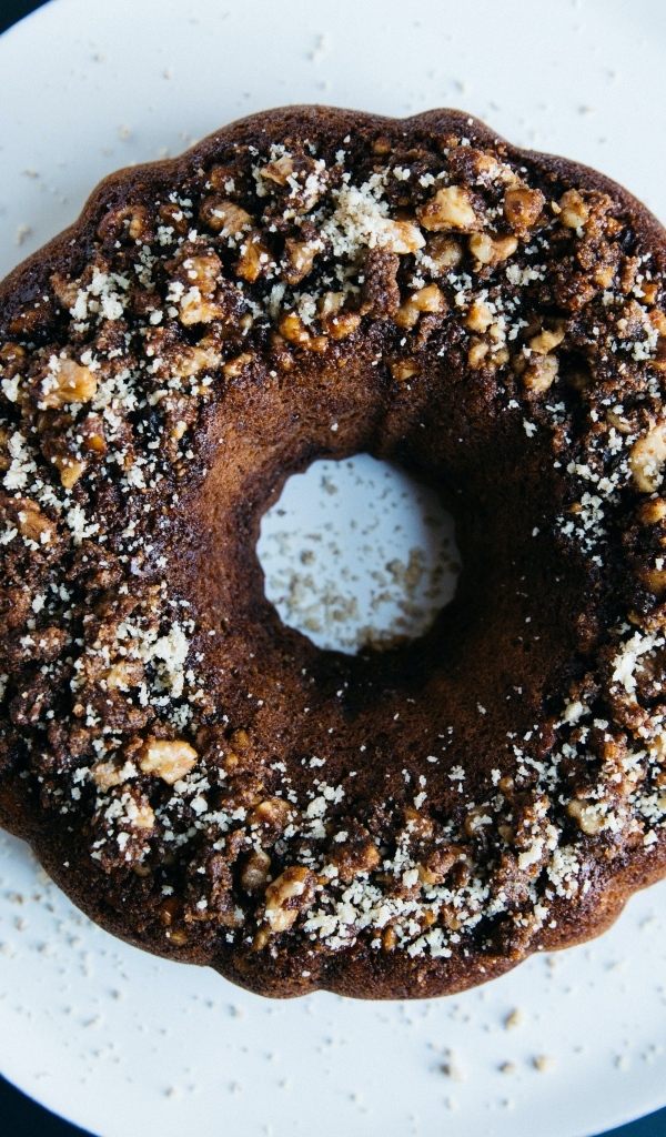 Круглый шоколадный кекс на большой белой тарелке