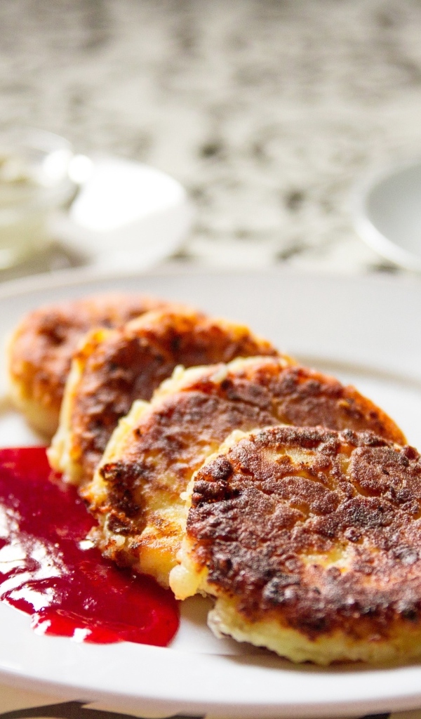 Румяные сырники на тарелке с джемом на завтрак