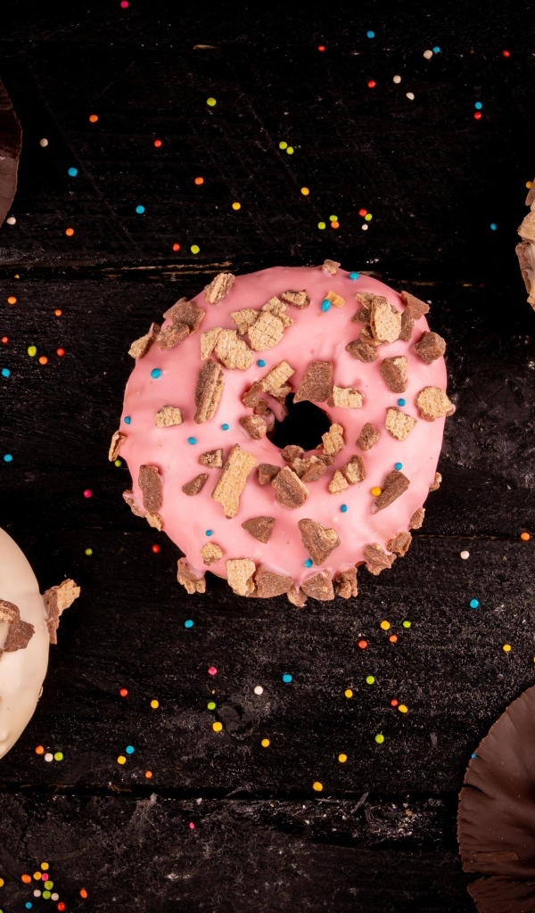 Три сладких пончика на черном столе