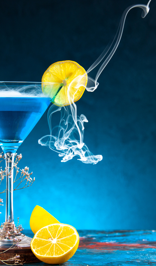 Голубой коктейль с лимоном на столе