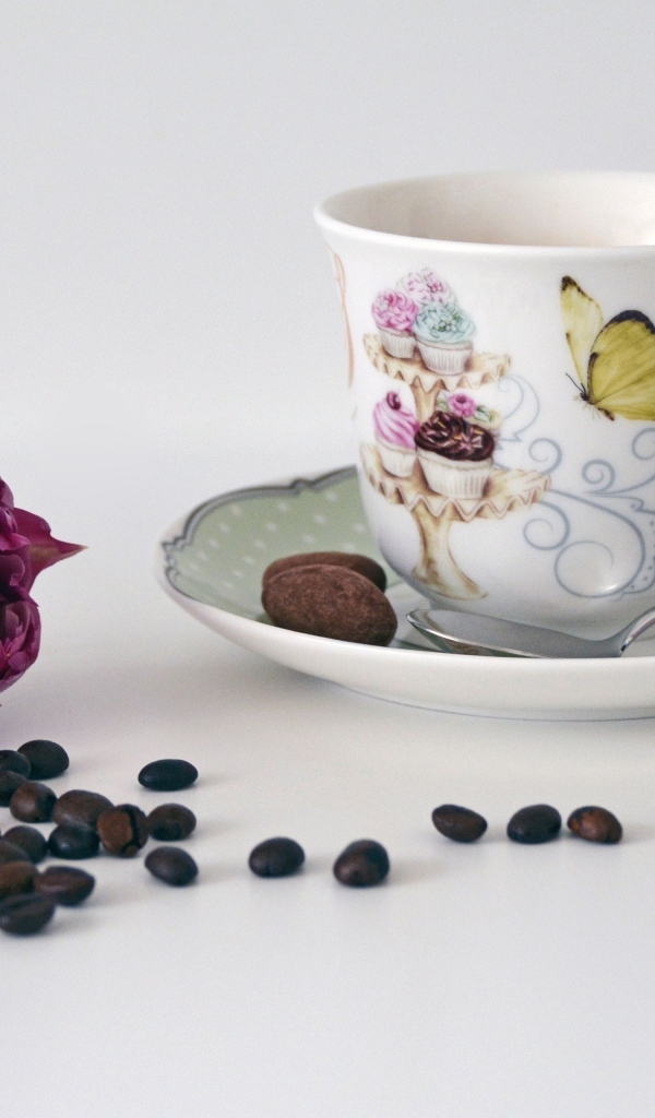 Чашка на столе с кофейными зернами и тюльпаном