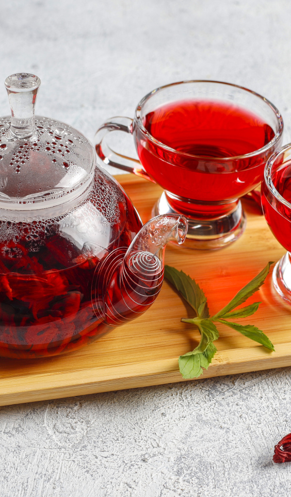 Красный чай в заварнике на подносе с чашками