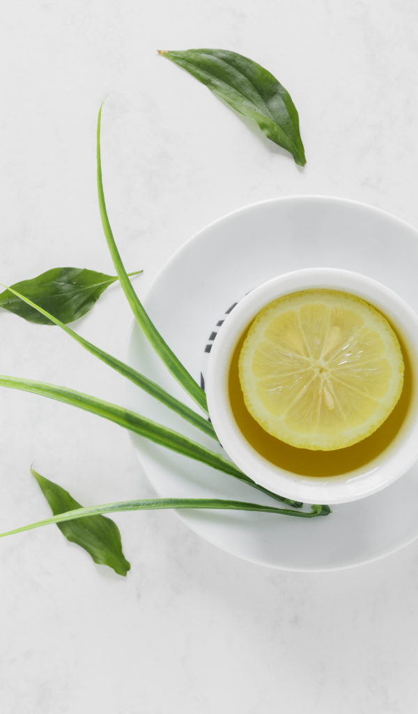 Чай в чашке на столе с кислым лимоном