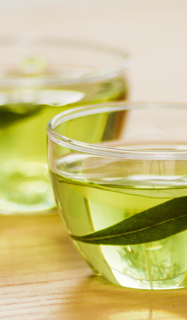 Две кружки зеленого чая с листьями