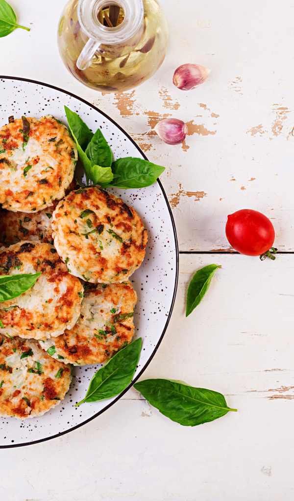 Куриные котлеты на большой белой тарелке  с соусом