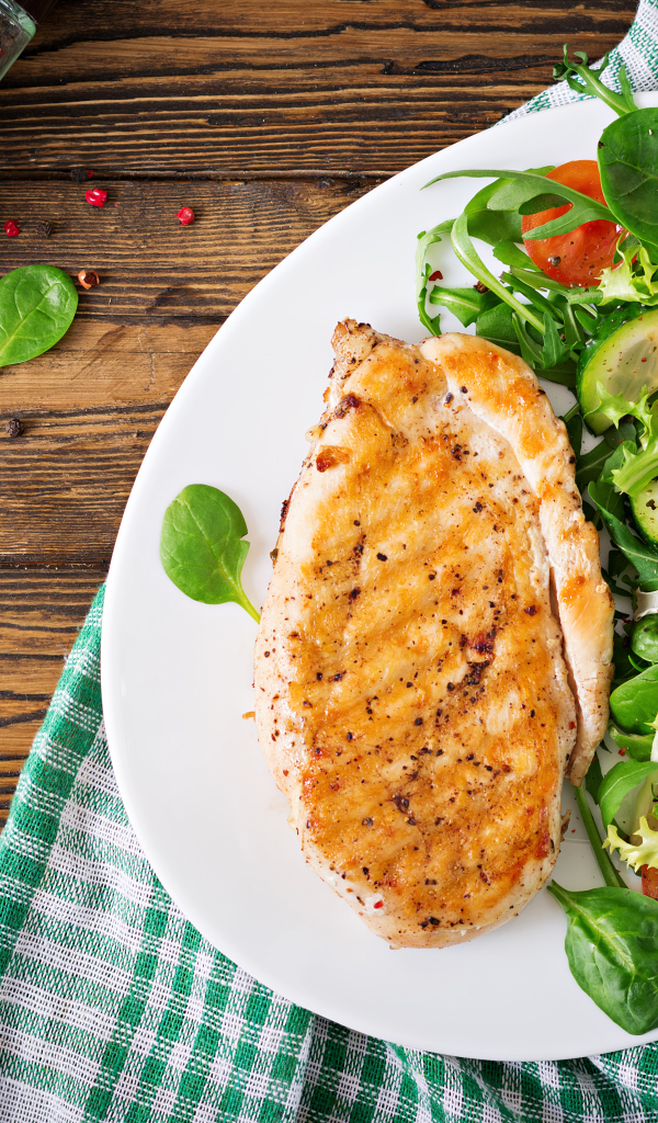 Жареная куриная грудка на тарелке с салатом