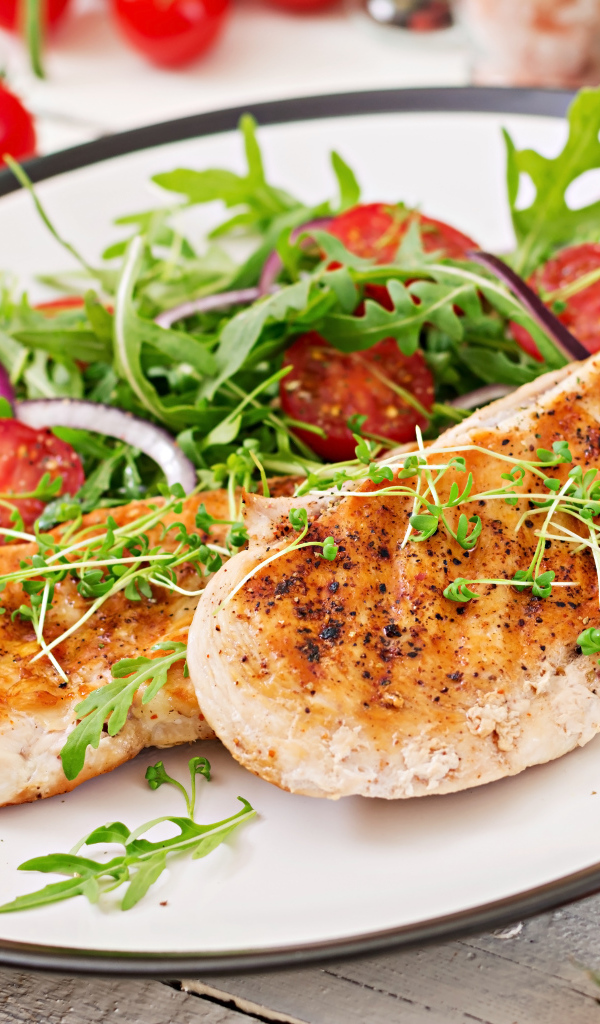 Жареная курица на тарелке с салатом