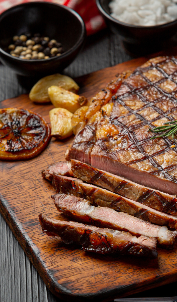 Кусок мясо барбекю на доске с овощами