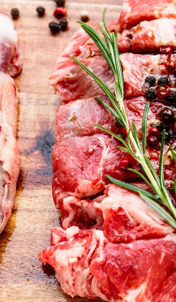 Кусок свежего мяса с перцем и розмарином