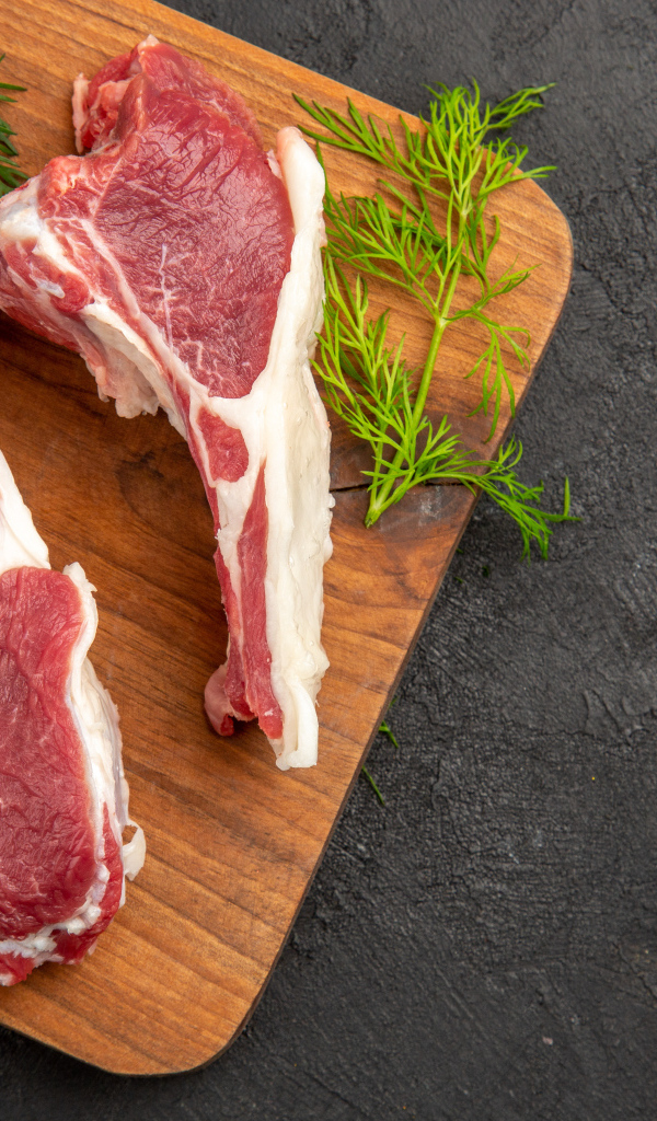 Свиные ребра на разделочной доске с укропом