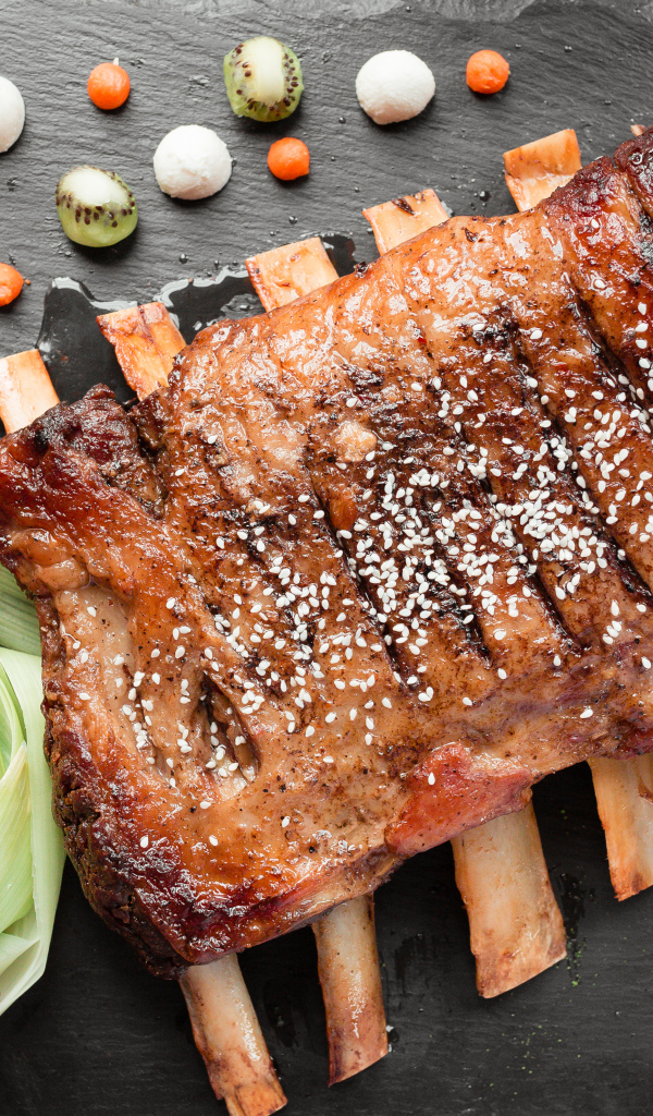 Свиные ребра на столе с овощами