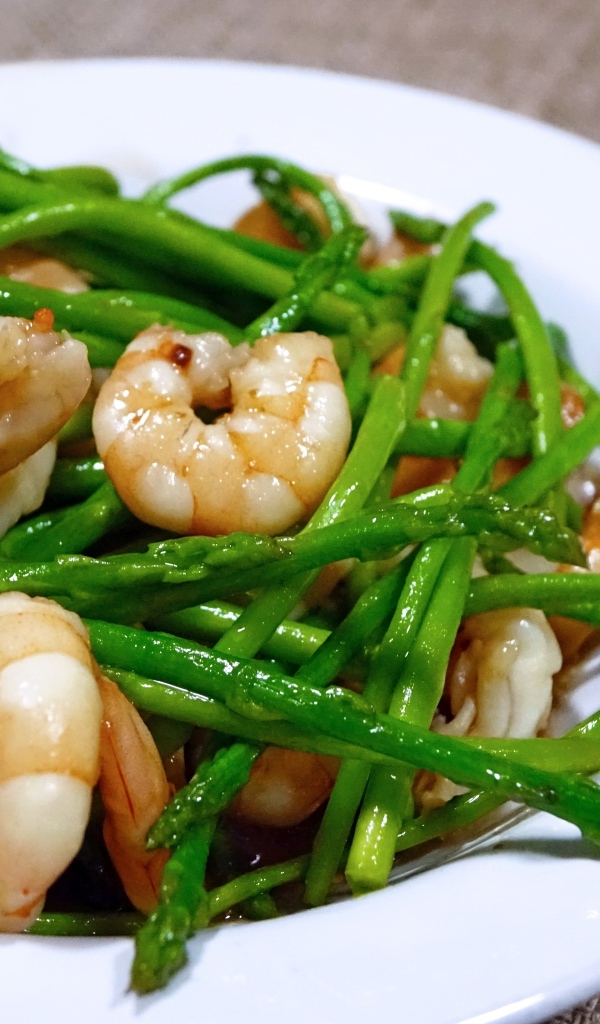 Спаржа с креветками в белой тарелке