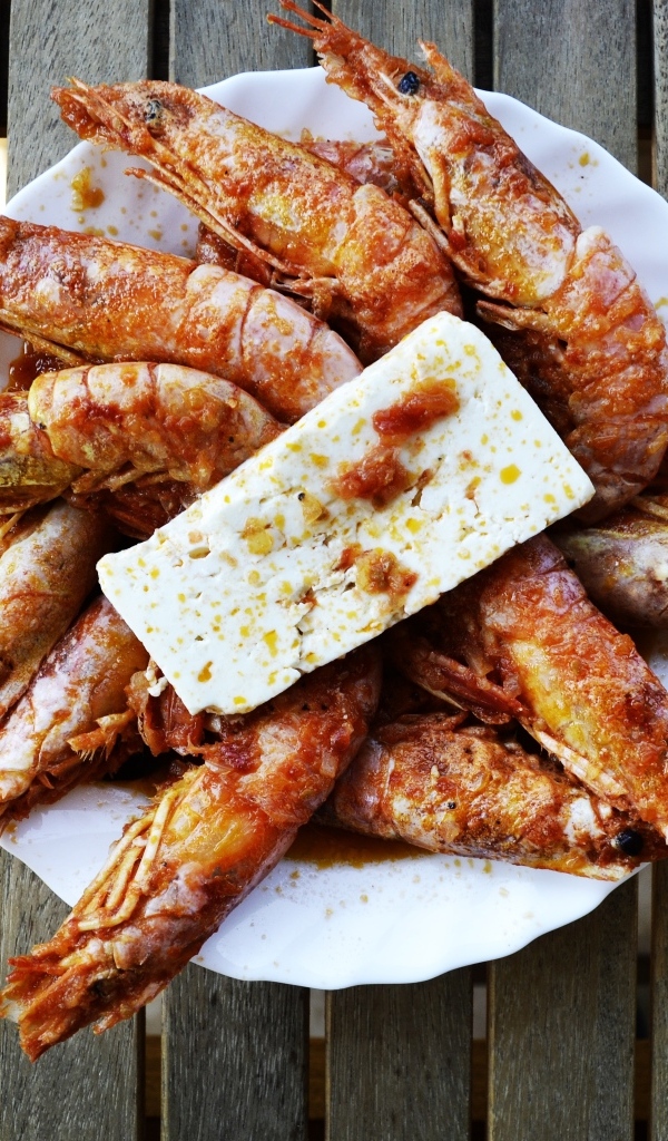 Жареные креветки на тарелке с сыром