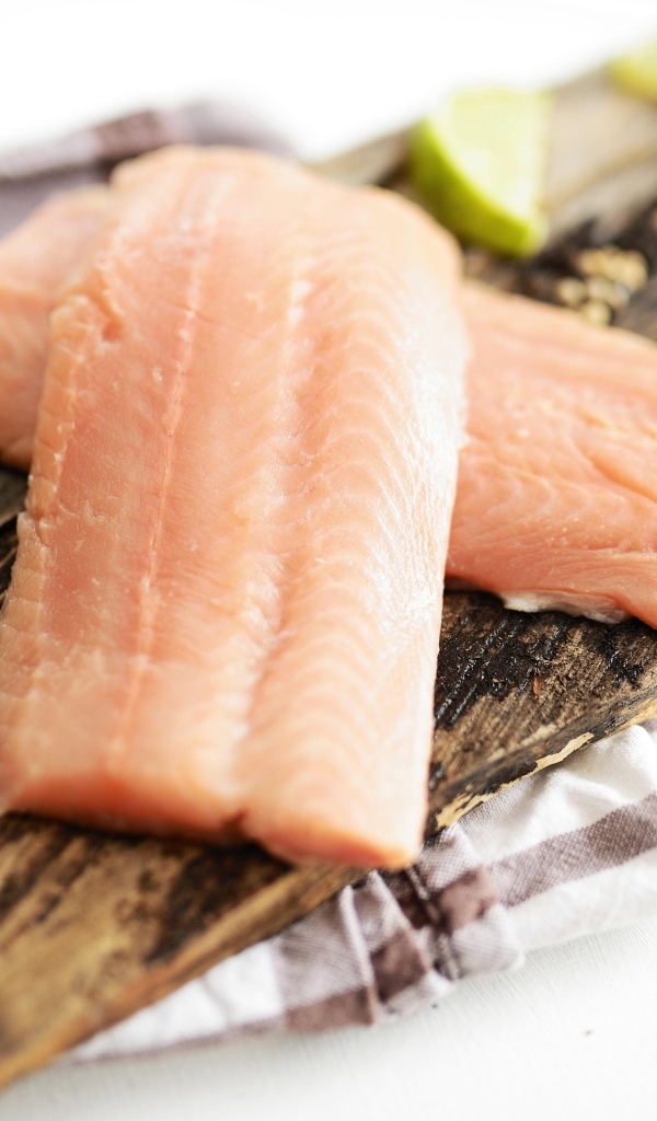 Кусочки рыбы на столе с лаймом