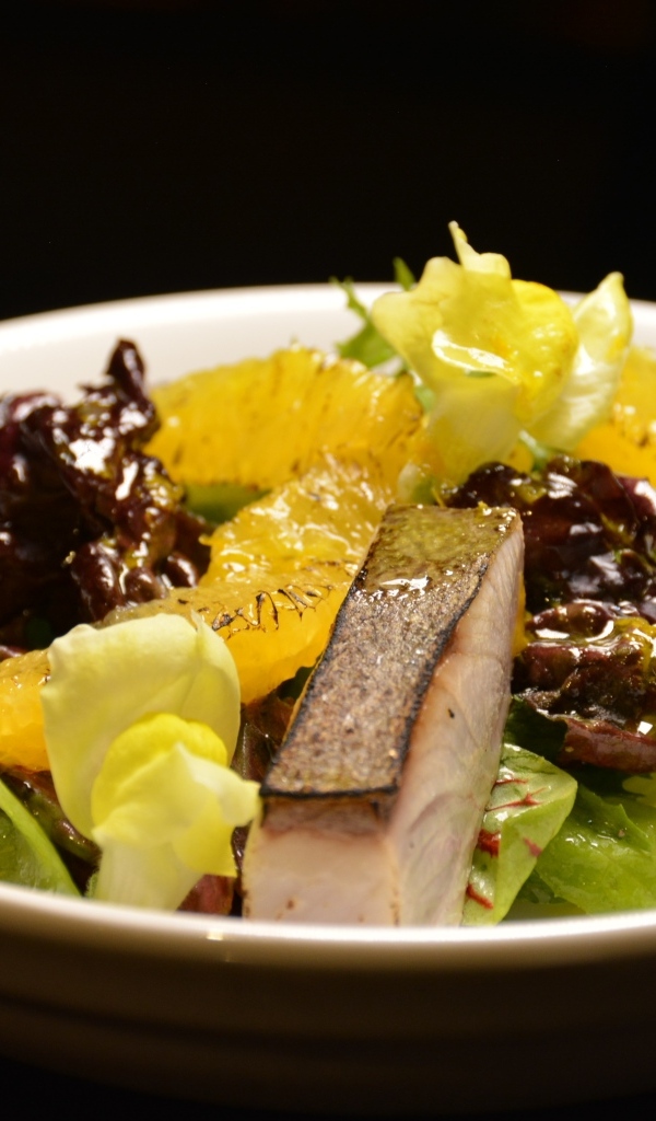 Кусочки рыбы с салатом и лимоном в тарелке