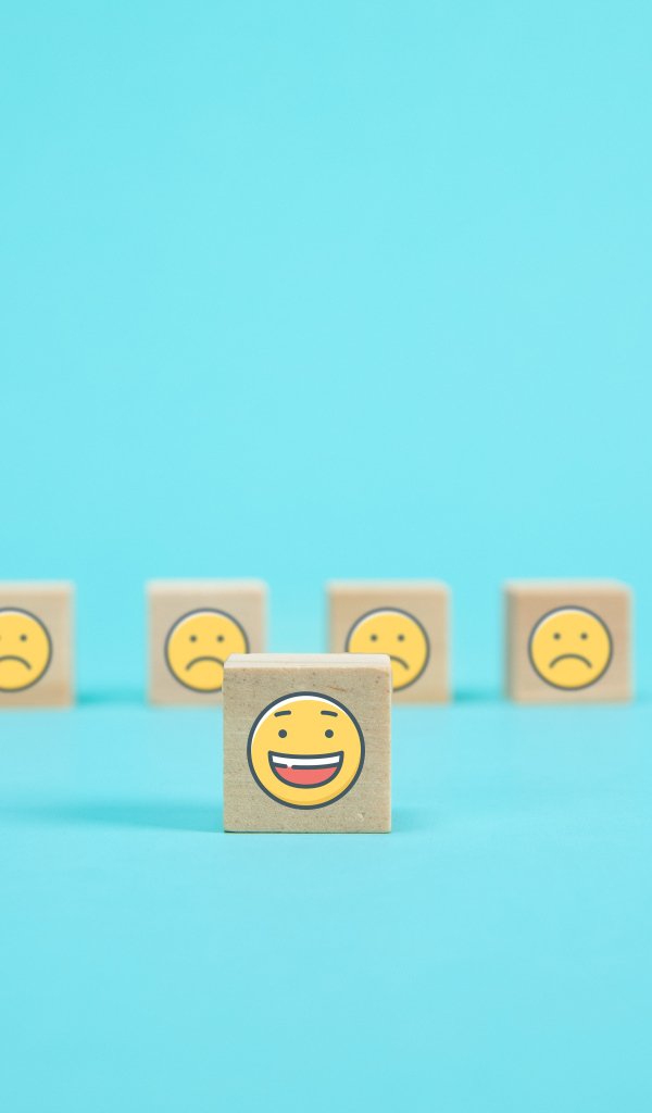 Деревянные кубики со смайлами на голубом фоне
