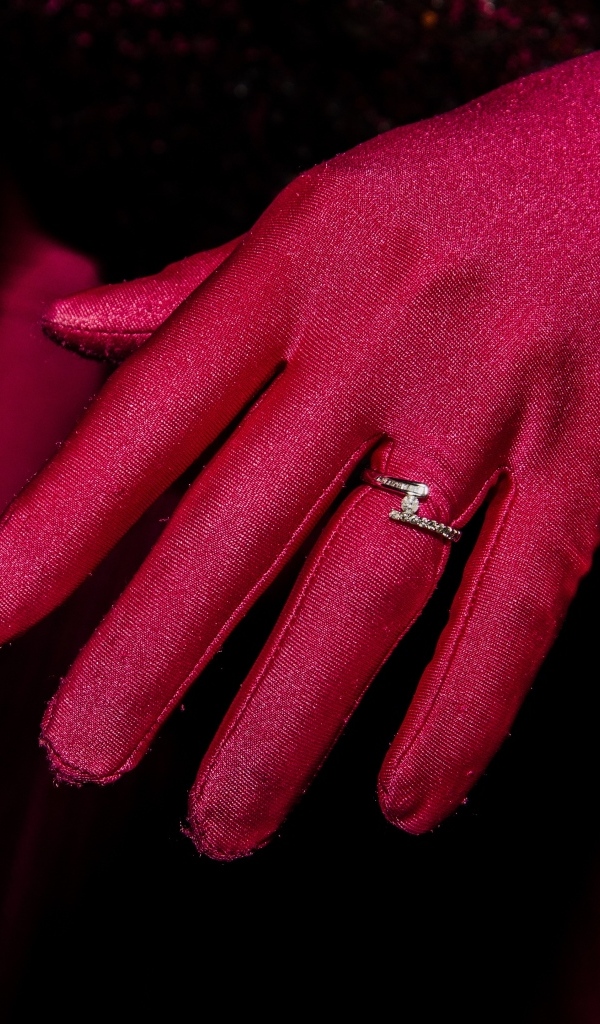 Женская рука с красной перчаткой и кольцом