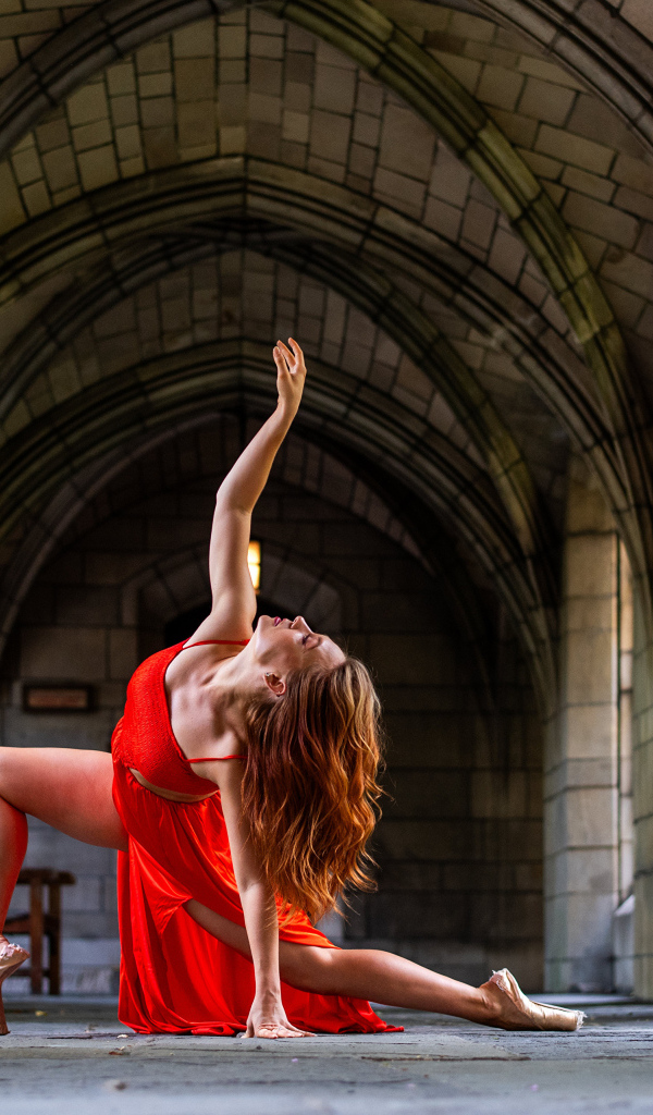 Девушка в красном наряде танцует в здании