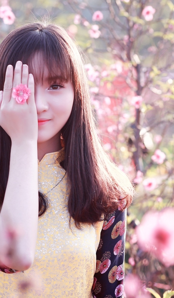 Девушка азиатка закрыла глаз рукой